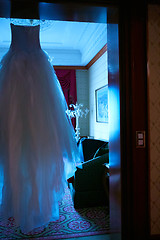 Image showing White Wedding dress hanging on a shoulders