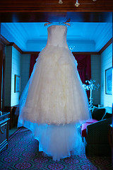 Image showing White Wedding dress hanging on a shoulders