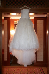 Image showing White Wedding dress hanging on a shoulders