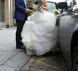 Image showing Beautiful couple, bride and groom getting into wedding limousine