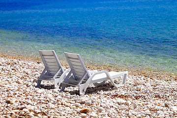 Image showing Two deck chairs on beach in sunny autumn day