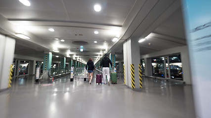 Image showing Travelers with baggage walking to flat escalator at Seoul airport