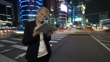 Image showing Woman with tablet PC in night Seoul, South Korea