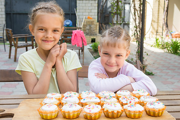 Image showing Two girls rejoice freshly baked Easter cupcakes
