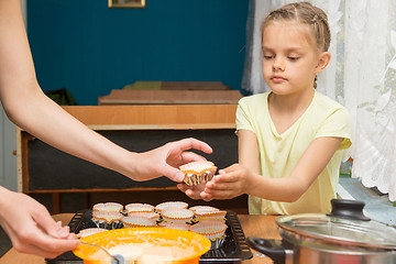 Image showing Daughter helps mum to prepare cupcakes for Easter