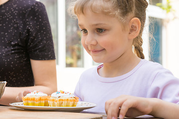 Image showing Happy girl is preparing to eat Easter cupcakes