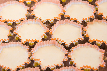 Image showing Many raw cakes in tins, ready for roasting