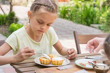 Image showing The girl carefully coated with confectionery glaze Easter cupcakes