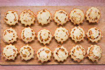 Image showing Top view of eighteen freshly baked muffins stuffed with boiled condensed milk