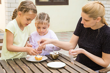 Image showing Mother and two daughters sprinkled cupcakes Easter candy sprinkles