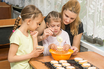 Image showing Mom teaches two daughters to cook Easter cupcakes