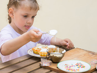 Image showing Girl puts focus on confectionery glaze Easter cupcakes
