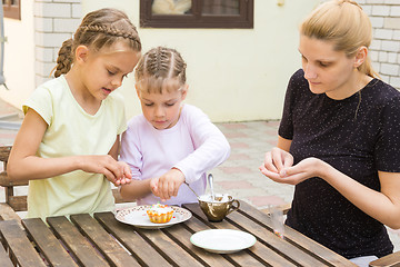 Image showing Mother and two daughters are preparing for the holiday Easter cupcakes