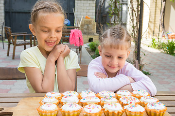 Image showing Two sisters with an appetite for looking at home-baked Easter cakes
