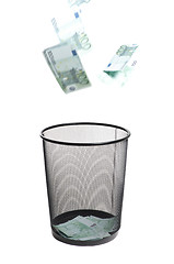 Image showing money flying into the trash