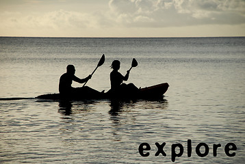 Image showing Kayakers silhouetted on the ocean, EXPLORE as concept text