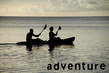 Image showing Kayakers silhouetted on the ocean, ADVENTURE as concept text