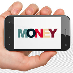 Image showing Business concept: Hand Holding Smartphone with Money on  display