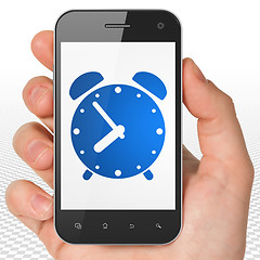 Image showing Timeline concept: Hand Holding Smartphone with Alarm Clock on display