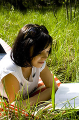 Image showing pretty young brunette readind in the park