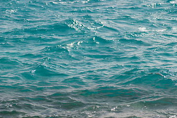 Image showing Photo closeup of beautiful clear turquoise sea ocean water surface with ripples low waves on seascape background, horizontal picture