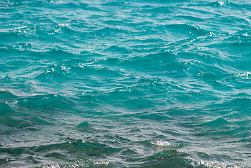 Image showing Photo closeup of beautiful clear turquoise sea ocean water surface with ripples low waves on seascape background, horizontal picture