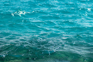 Image showing Photo closeup of beautiful clear turquoise sea ocean water surface with ripples low waves on seascape background, horizontal picture