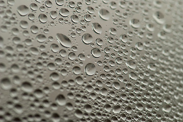 Image showing close-up of water drops on the gray background with town reflection