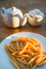 Image showing French fries with ketchup and on wooden table. Top view sunny evening