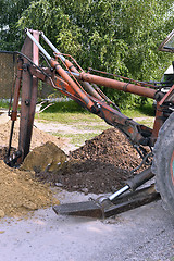 Image showing Excavator bucket digging a trench in the dirt ground