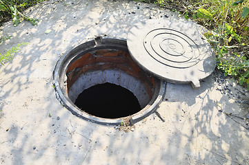 Image showing Concrete cesspit with an open hatch on the ground in the summer