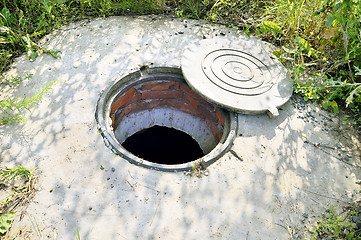 Image showing Concrete cesspit with an open hatch on the ground in the summer