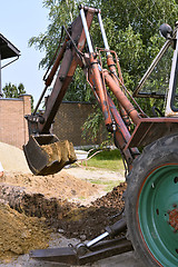 Image showing Excavator bucket digging a trench in the dirt ground