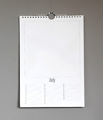 Image showing Simple old birthday calendar hanging on a grey wall - July
