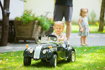Image showing The little baby girl playing at car
