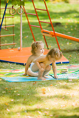 Image showing The two little baby girls playing at outdoor playground