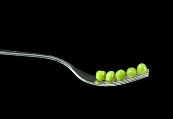 Image showing Fresh green peas on a silver fork