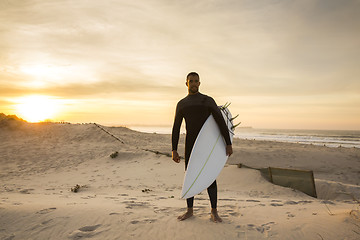 Image showing A surfer with his surfboard 