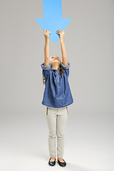 Image showing Girl holding a big blue arrow