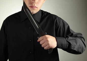 Image showing standing man in black with knife