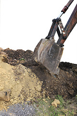 Image showing Excavator bucket digging a trench in the dirt ground