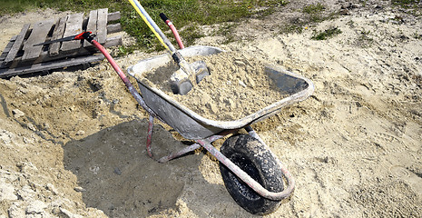 Image showing A pile of sand, a shovel and a construction truck for transporta