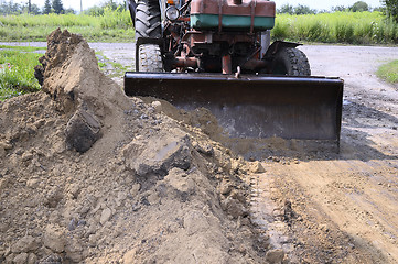 Image showing Excavator bucket digging a trench in the dirt ground