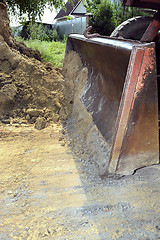 Image showing Excavator bucket digging a trench in the dirt ground