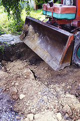 Image showing Excavator bucket digging a trench in the dirt ground