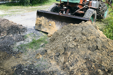 Image showing Excavator bucket digging a trench in the dirt ground