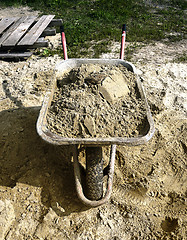 Image showing A pile of sand, a shovel and a construction truck for transportation of goods
