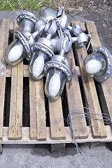 Image showing Used in the production of waste lamps are stacked on a wooden pallet on the floor