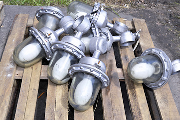 Image showing Used in the production of waste lamps are stacked on a wooden pallet on the floor