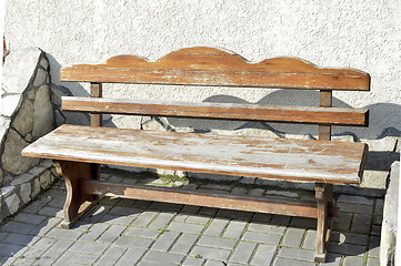 Image showing Old wooden vintage empty bench standing on an open paved area